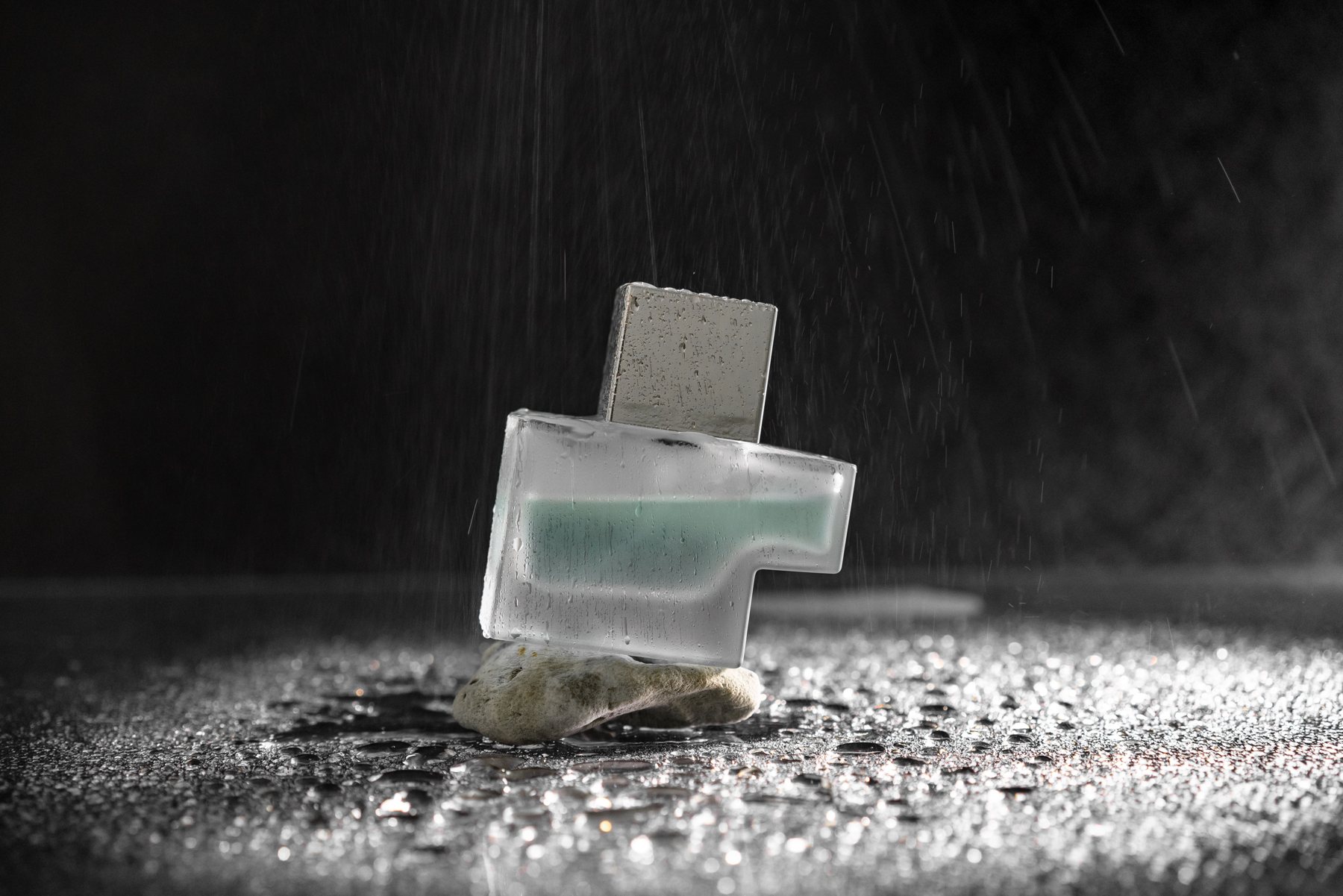 Glass fragrance bottle on a dark textured surface